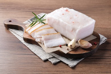 Pork fatback with rosemary, garlic and peppercorns on wooden table