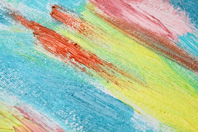 Photo of Strokes of colorful acrylic paints on canvas, closeup