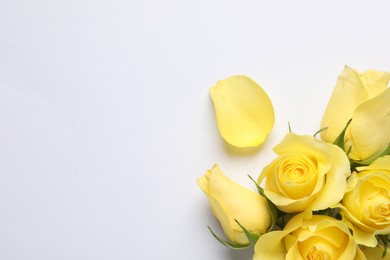 Photo of Beautiful yellow roses and petal on white background, flat lay. Space for text