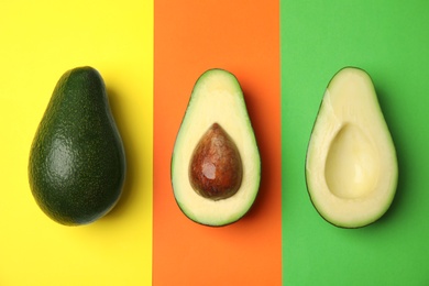 Photo of Cut and whole fresh ripe avocados on color background, flat lay