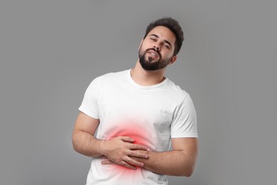 Image of Man suffering from stomach pain on grey background