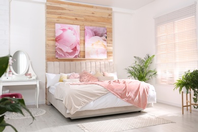 Photo of Stylish room interior with large comfortable bed and beautiful paintings
