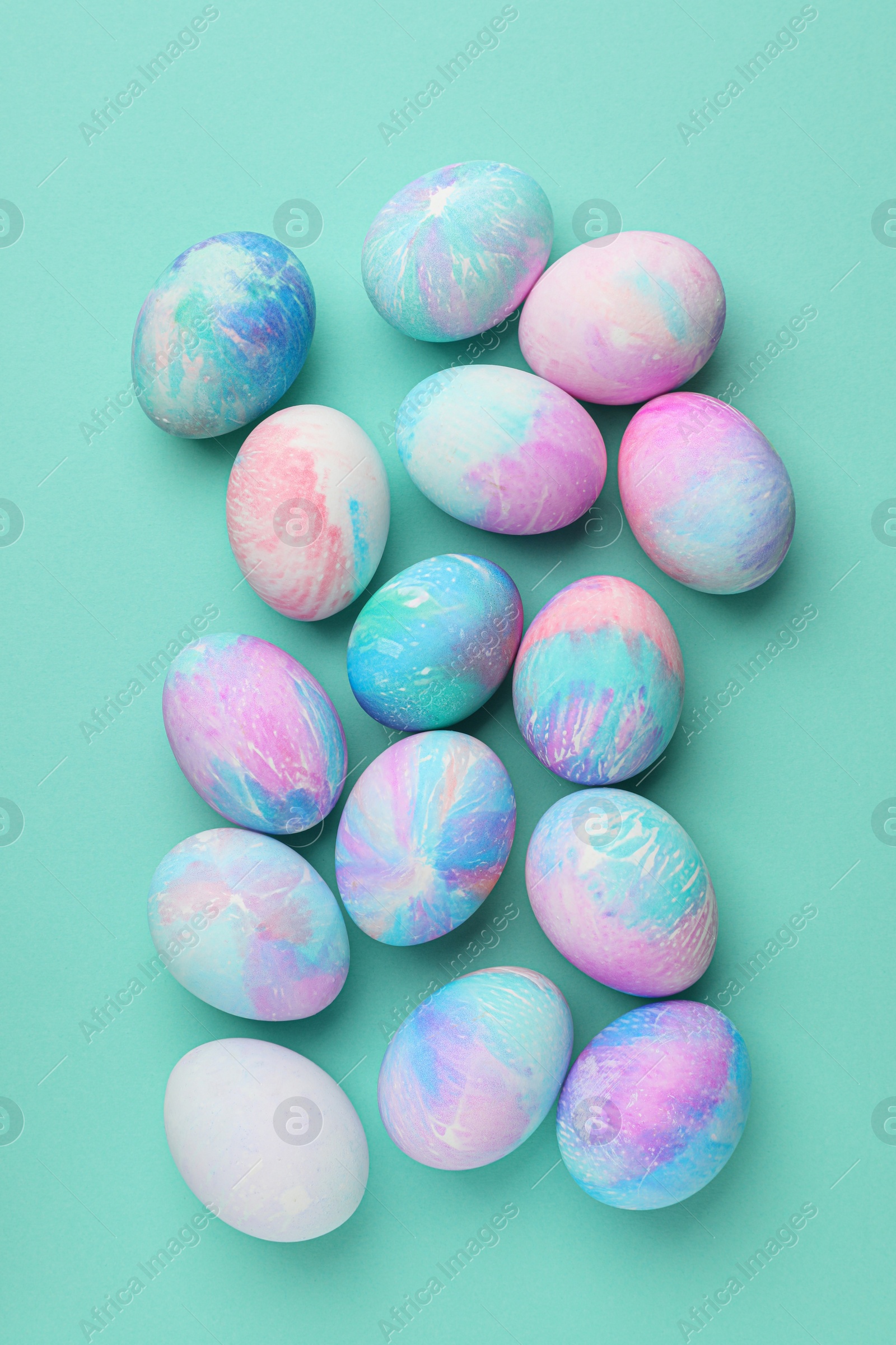 Photo of Many decorated Easter eggs on turquoise background, flat lay