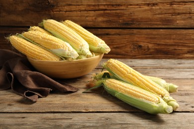 Photo of Tasty sweet corn cobs on wooden table