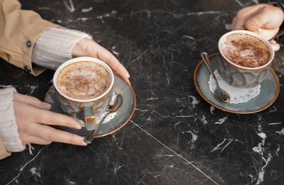 Photo of Couple enjoying tasty aromatic coffee at table, closeup view