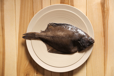 Photo of Fresh raw fish on wooden table, top view