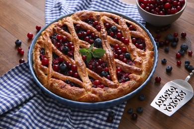Photo of Delicious currant pie with fresh berries on wooden table