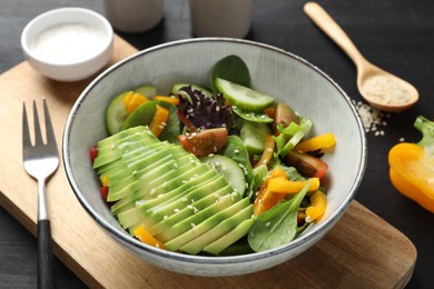 Photo of Healthy dish high in vegetable fats on black wooden table, closeup