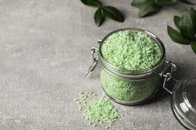 Photo of Jar with green sea salt on light grey table. Space for text