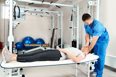 Photo of Physiotherapist working with patient in rehabilitation center