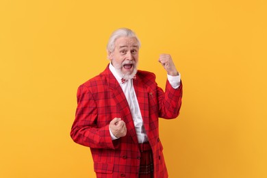 Photo of Portrait of grandpa with stylish red suit and bowtie on yellow background