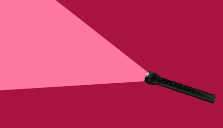 Image of Flashlight illuminating pink background. Light symbolizing search, guidance, direction and other