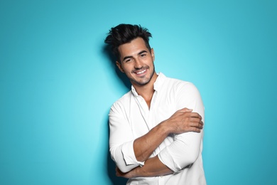 Photo of Young man with trendy hairstyle posing on color background