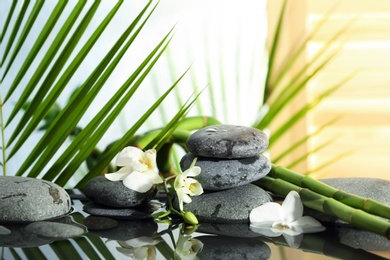 Photo of Spa stones, flowers and bamboo branches in water
