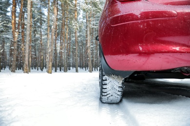 Photo of Snowy country road with car on winter day, closeup. Space for text