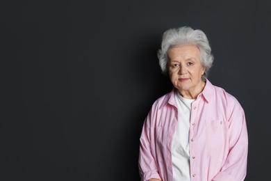 Photo of Portrait of mature woman on black background. Space for text