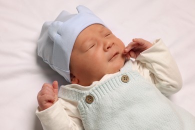 Photo of Cute newborn baby lying on white blanket