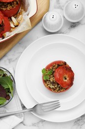 Photo of Delicious stuffed tomatoes with minced beef, bulgur and mushrooms on white marble table, flat lay