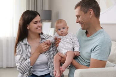 Photo of Happy family with their cute baby in living room at home