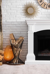 Photo of Firewood in holder near modern fireplace in living room