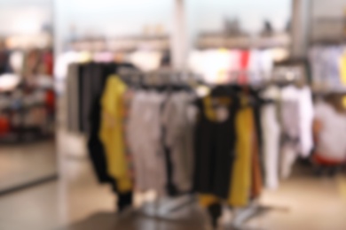 Photo of Blurred view of modern store with different clothes
