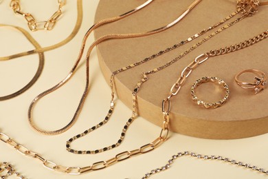 Photo of Metal chains and other different accessories on beige background