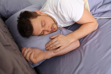 Photo of Handsome man sleeping on pillow at home. Bedtime