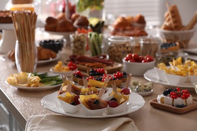 Variety of snacks on wooden table in buffet style indoors