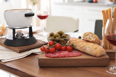 Different products and fondue pot on table indoors