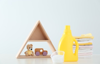 Photo of Detergent, toys and children's clothes on white table