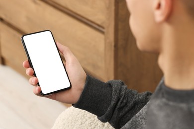 Photo of Man using smartphone with blank screen indoors, closeup. Mockup for design