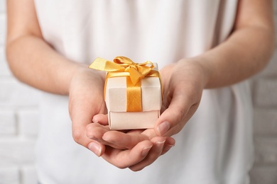 Photo of Woman holding beautiful gift box, closeup