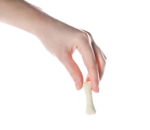 Photo of Woman holding bone shaped dog cookie on white background, closeup