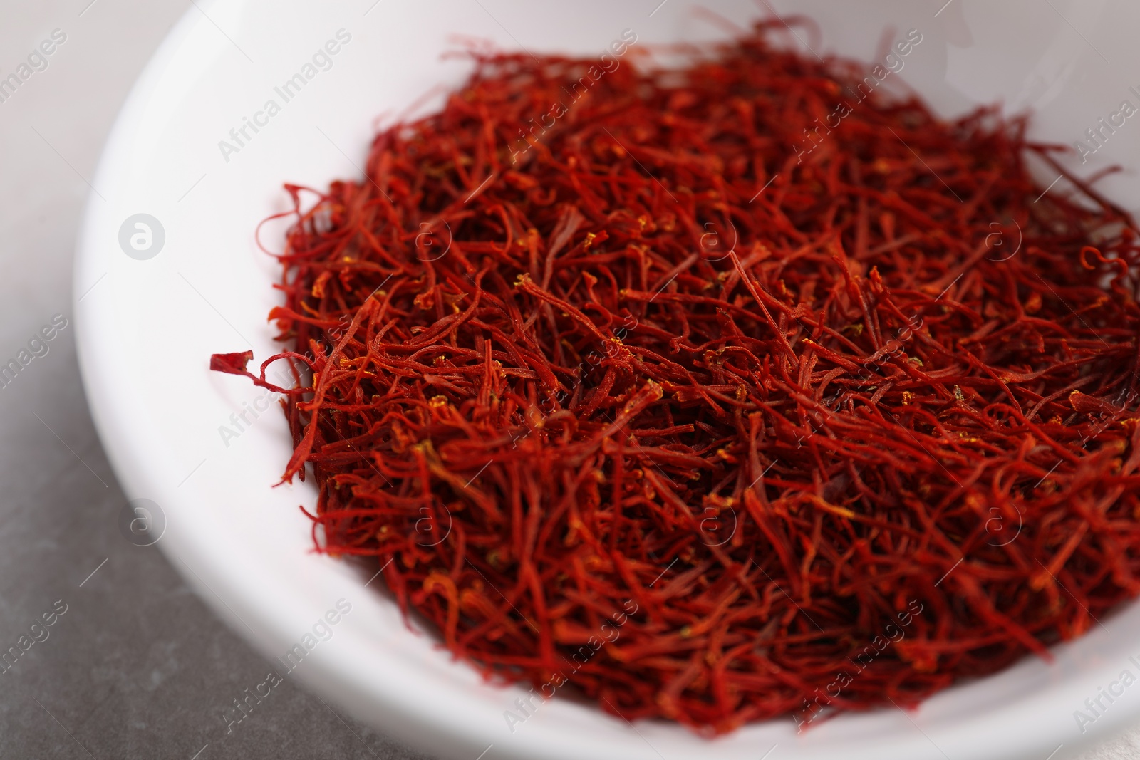 Photo of Aromatic saffron in bowl on table, closeup