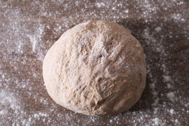 Photo of Fresh sourdough and flour on wooden table, top view