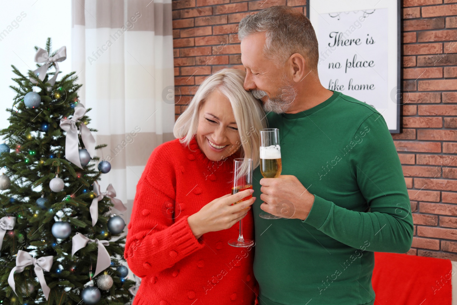 Photo of Mature couple with glasses of champagne at home. Christmas celebration