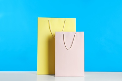 Photo of Gift bags on white table against light blue background