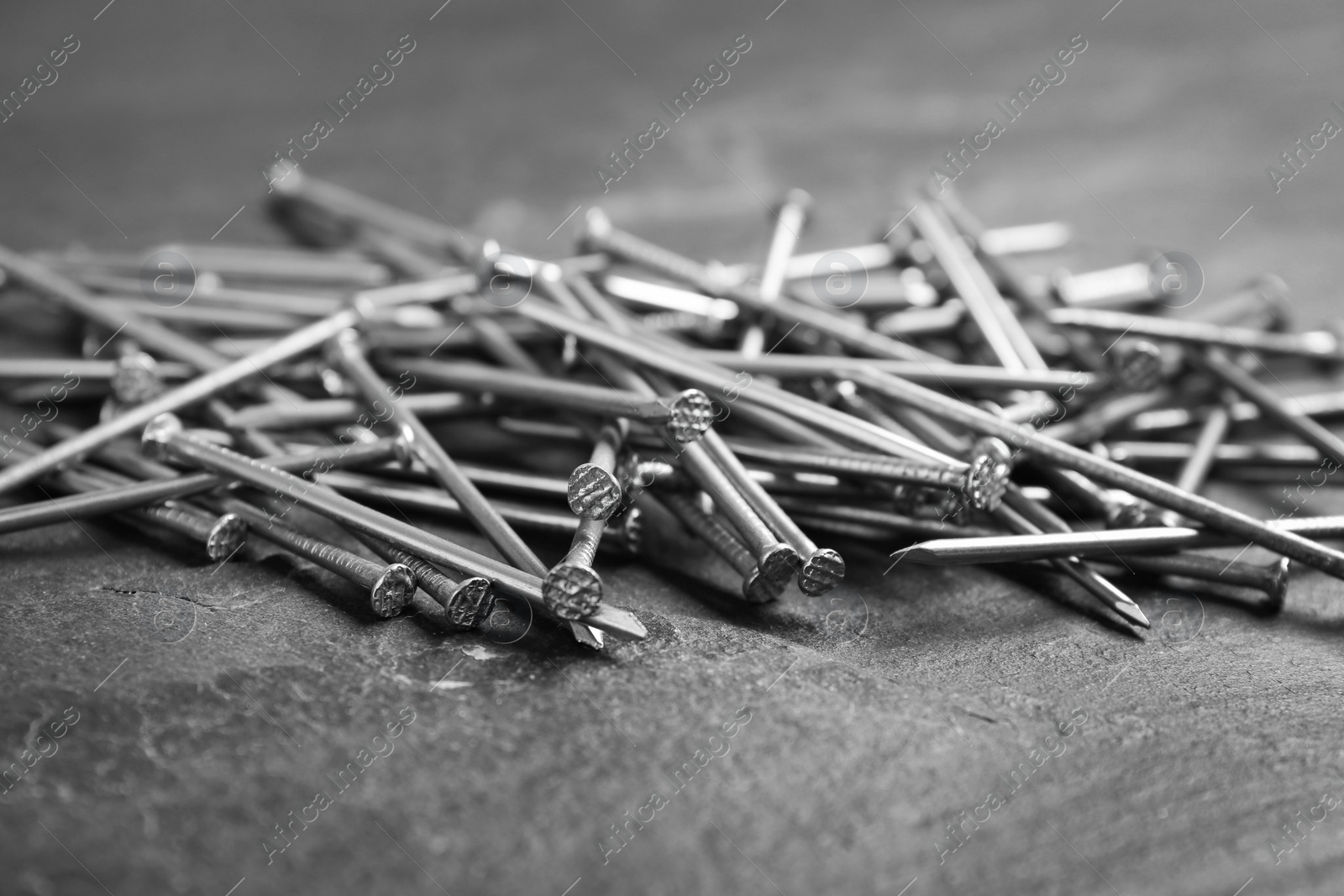 Photo of Pile of metal nails on grey background