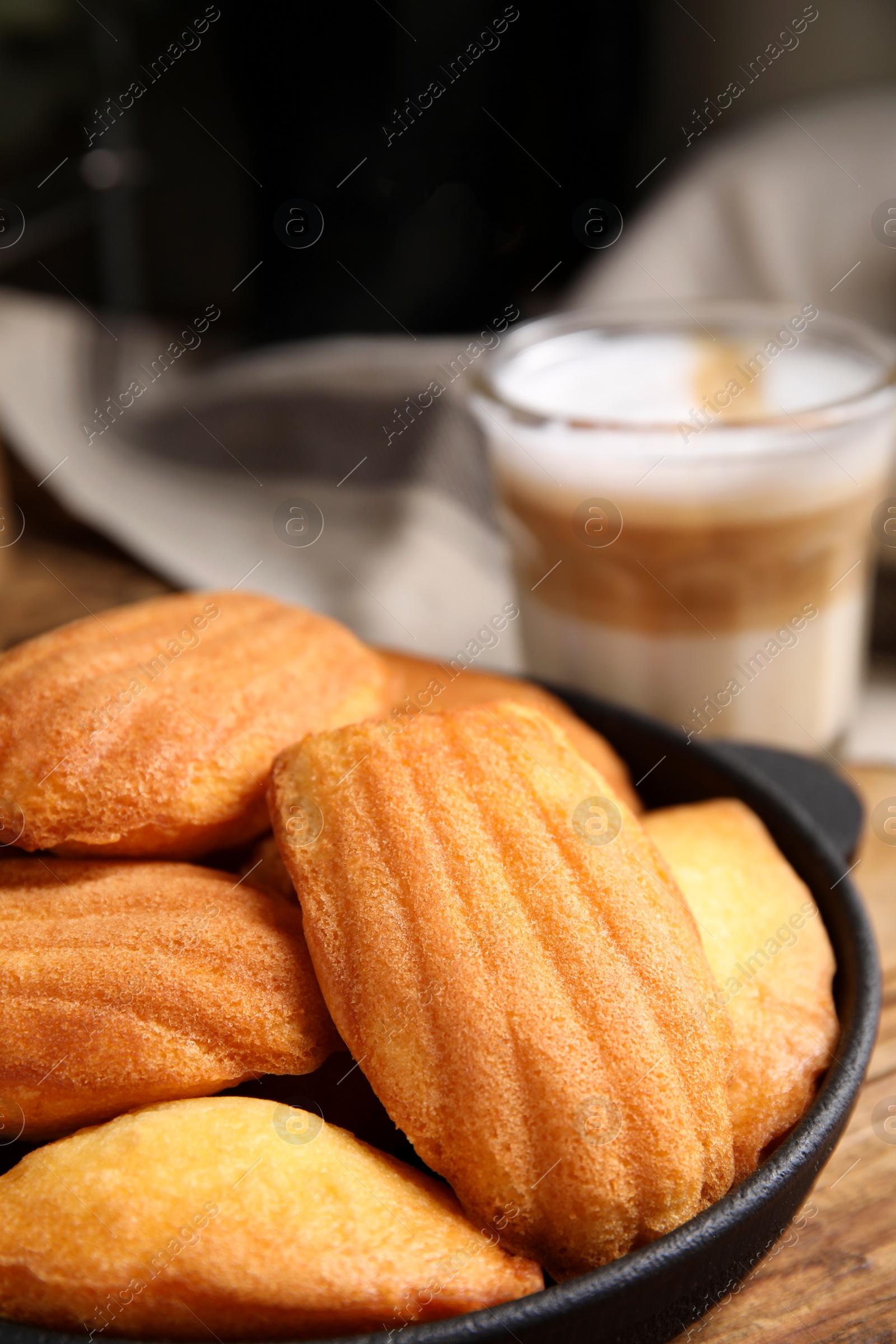 Photo of Delicious madeleine cakes in frying pan on table, closeup