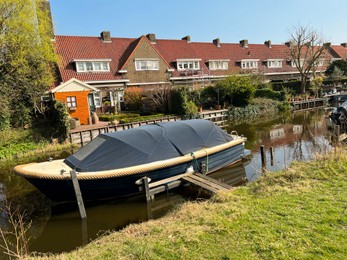 Beautiful city canal with moored boat on sunny spring day