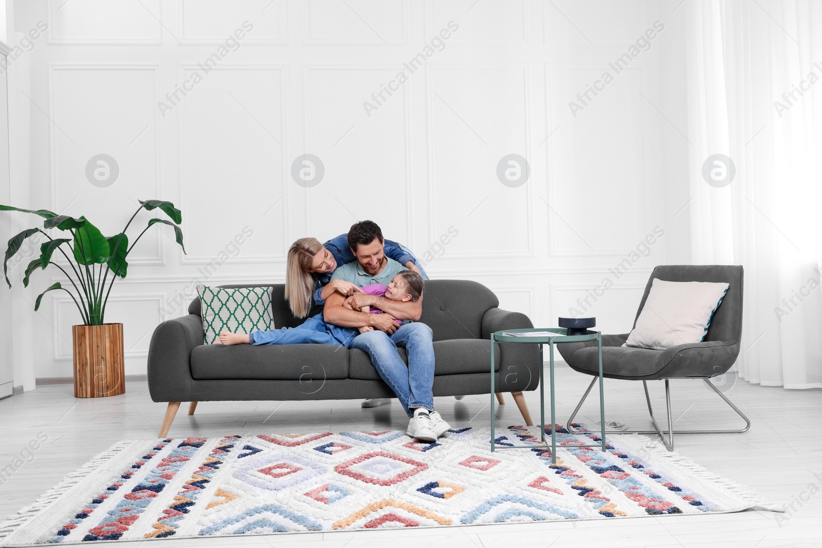 Photo of Happy family having fun together on sofa at home