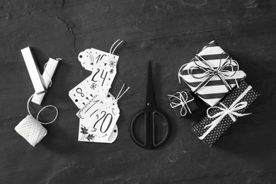 Photo of Flat lay composition with gift boxes on black table. Creating advent calendar