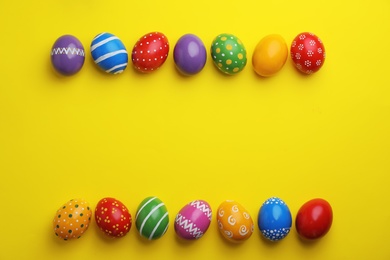 Photo of Decorated Easter eggs and space for text on color background, top view
