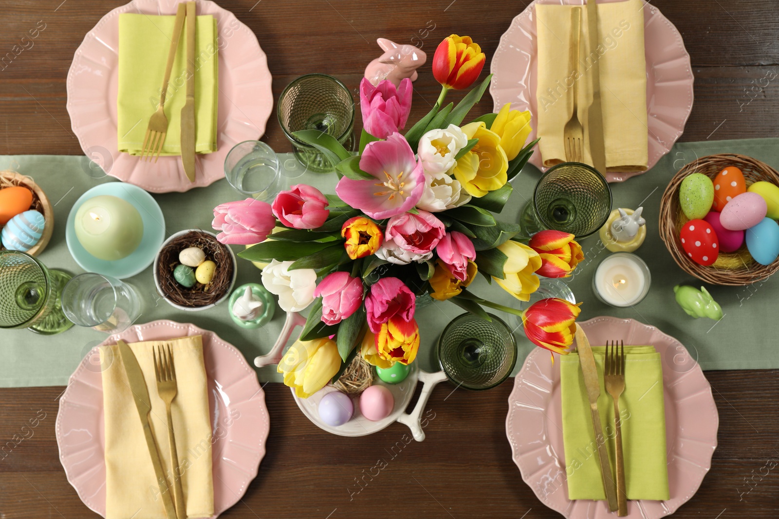 Photo of Easter celebration. Festive table setting with beautiful flowers and painted eggs, flat lay