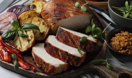 Photo of Delicious grilled meat and vegetables served on light grey table, closeup