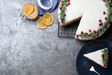 Flat lay composition with traditional Christmas cake on grey table. Space for text