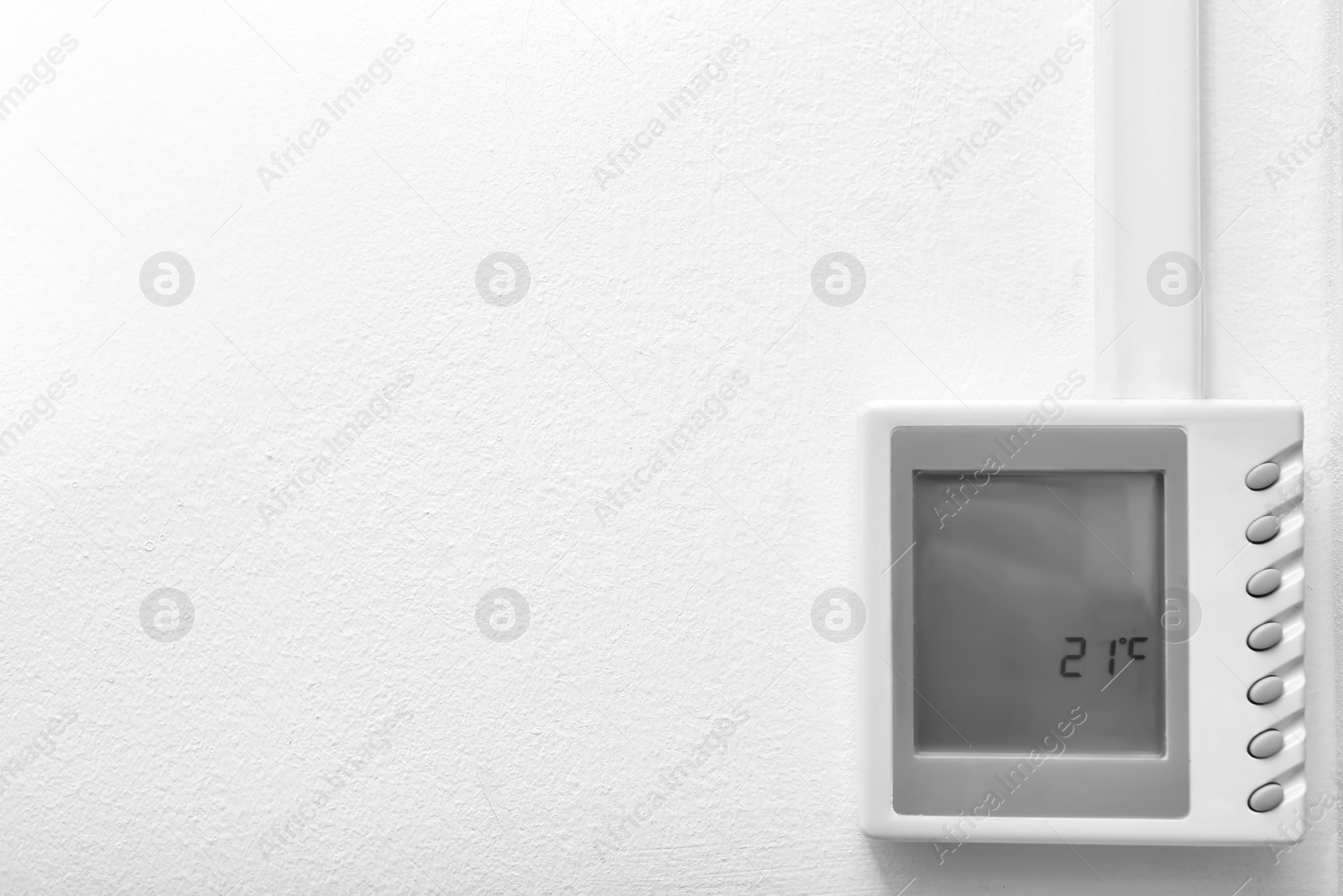 Photo of Modern thermostat and space for text on white wall. Heating system