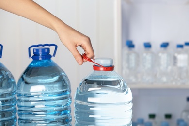 Photo of Woman with bottle of water on blurred background, closeup