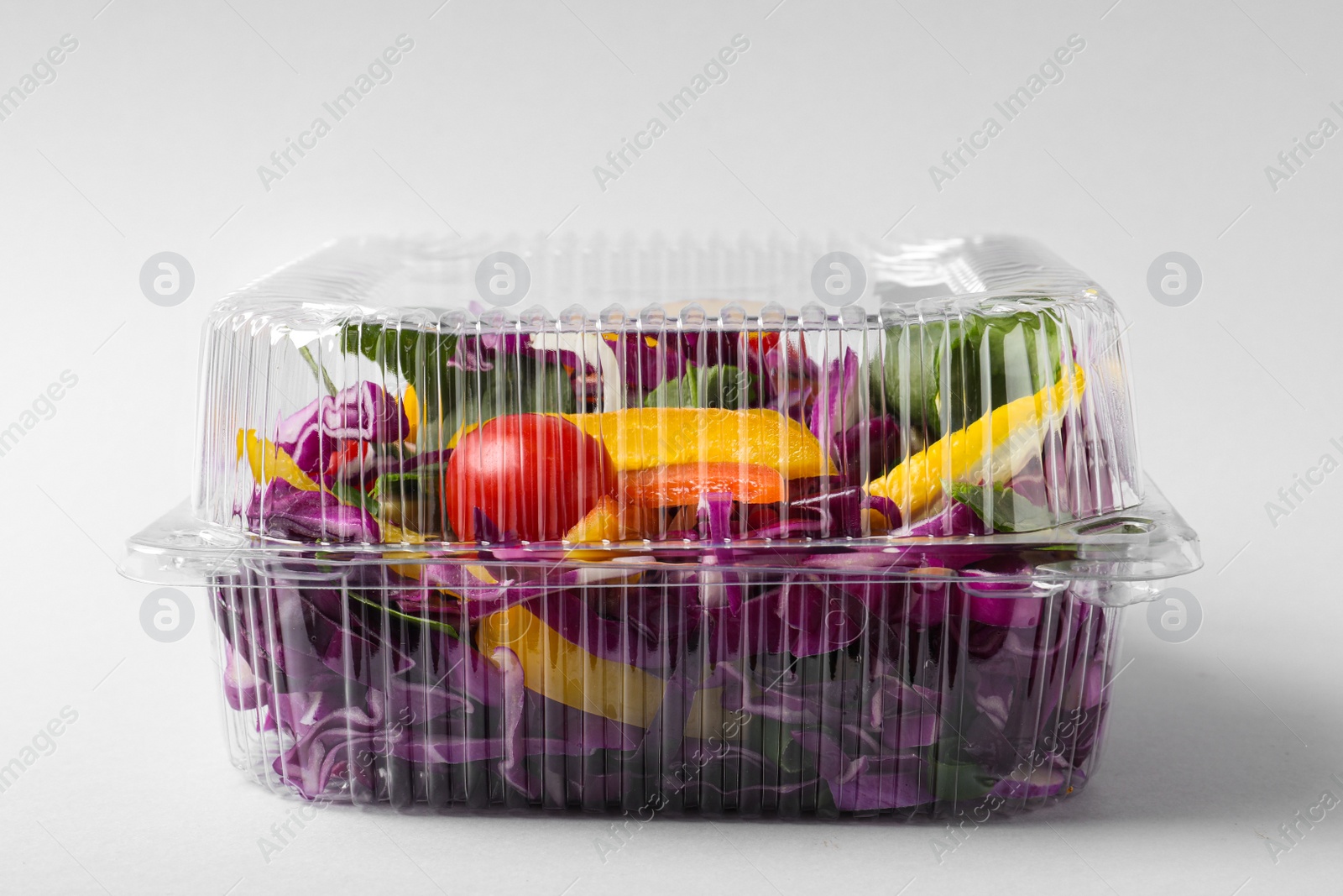 Photo of Plastic container with fresh salad on light grey background