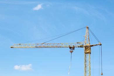 Photo of Modern tower crane against blue sky. Construction site